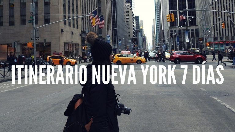 CRUZANDO LA CALLE EN NUEVA YORK CON LOS EDIFICIOS ALTOS DETRÁS Y LOS COCHES Y TAXIS CIRCULANDO DE FONDO